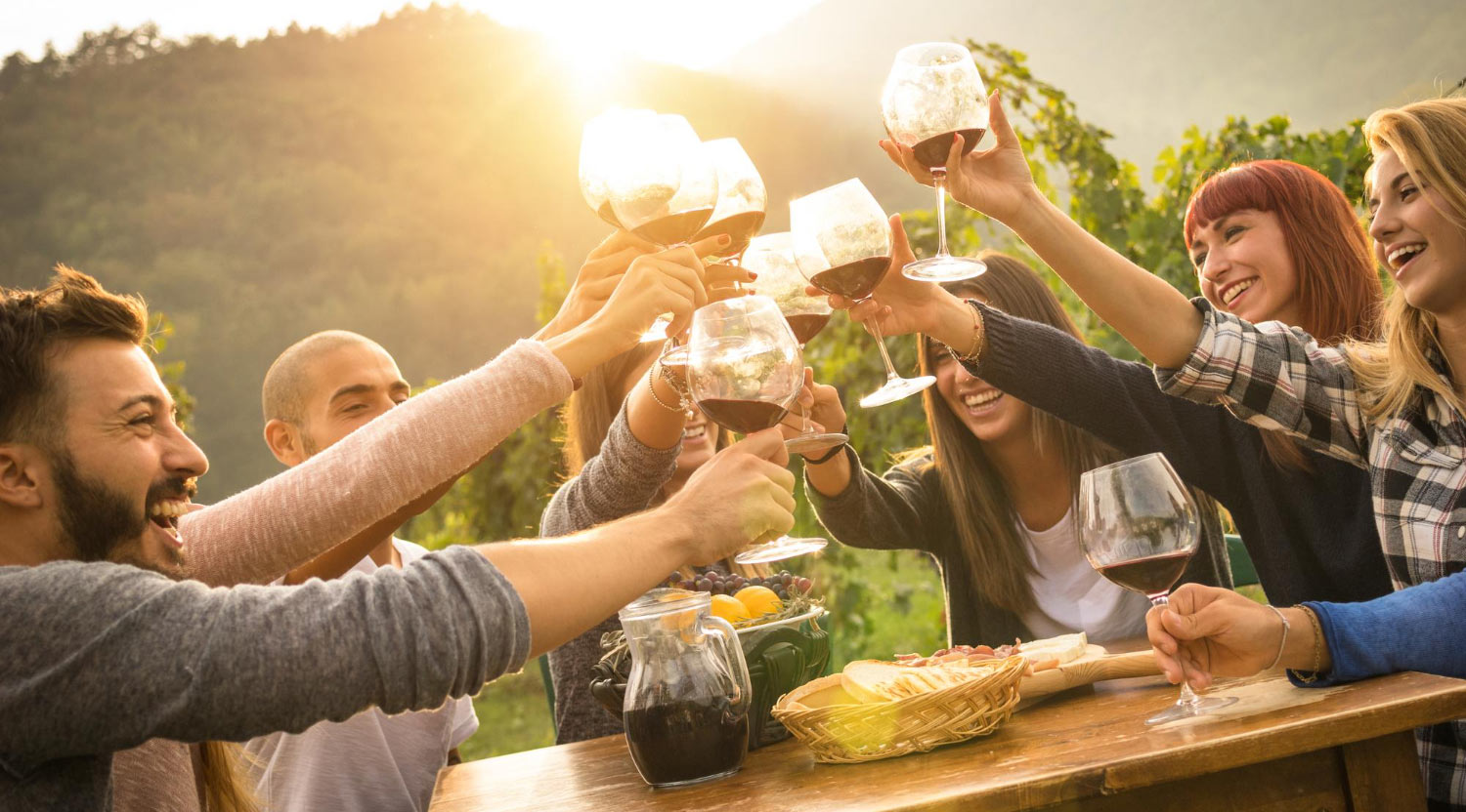 Menschen stoßen mit Wein an